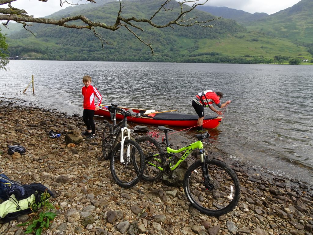 Unloading bikes from canoe on upper Loch Lomond section of A82